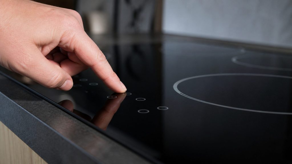 the touch control strip of an electric cooktop, close and low — these are touch, not knobs