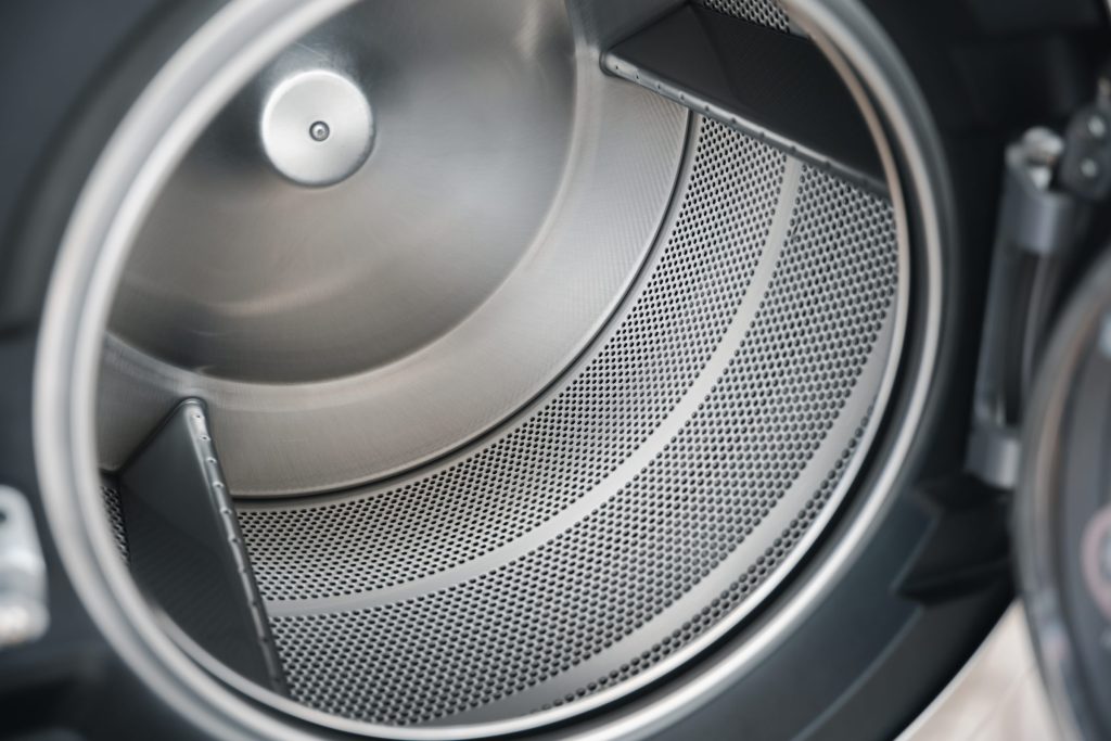the perforated drum wall and lifting vanes seen through the door